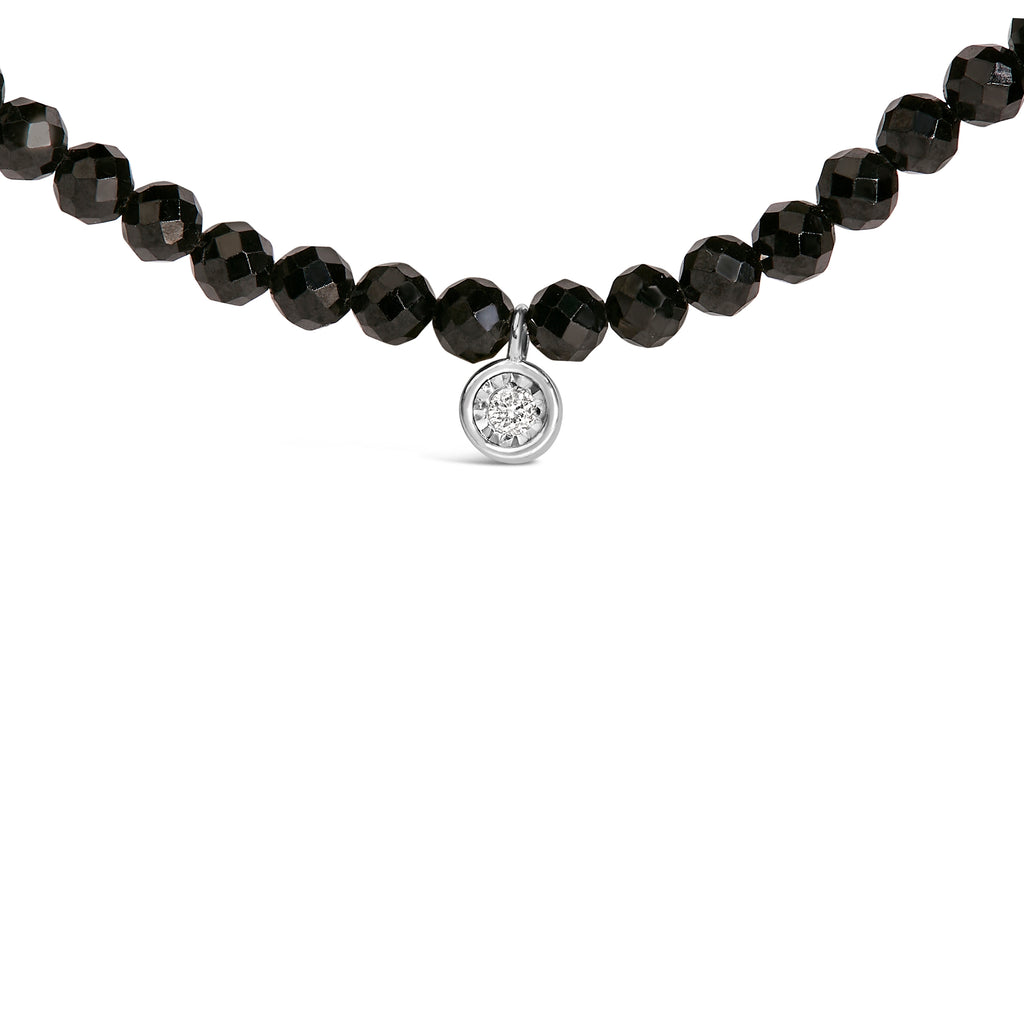 Necklace with black beads and a silver pendant on a white background