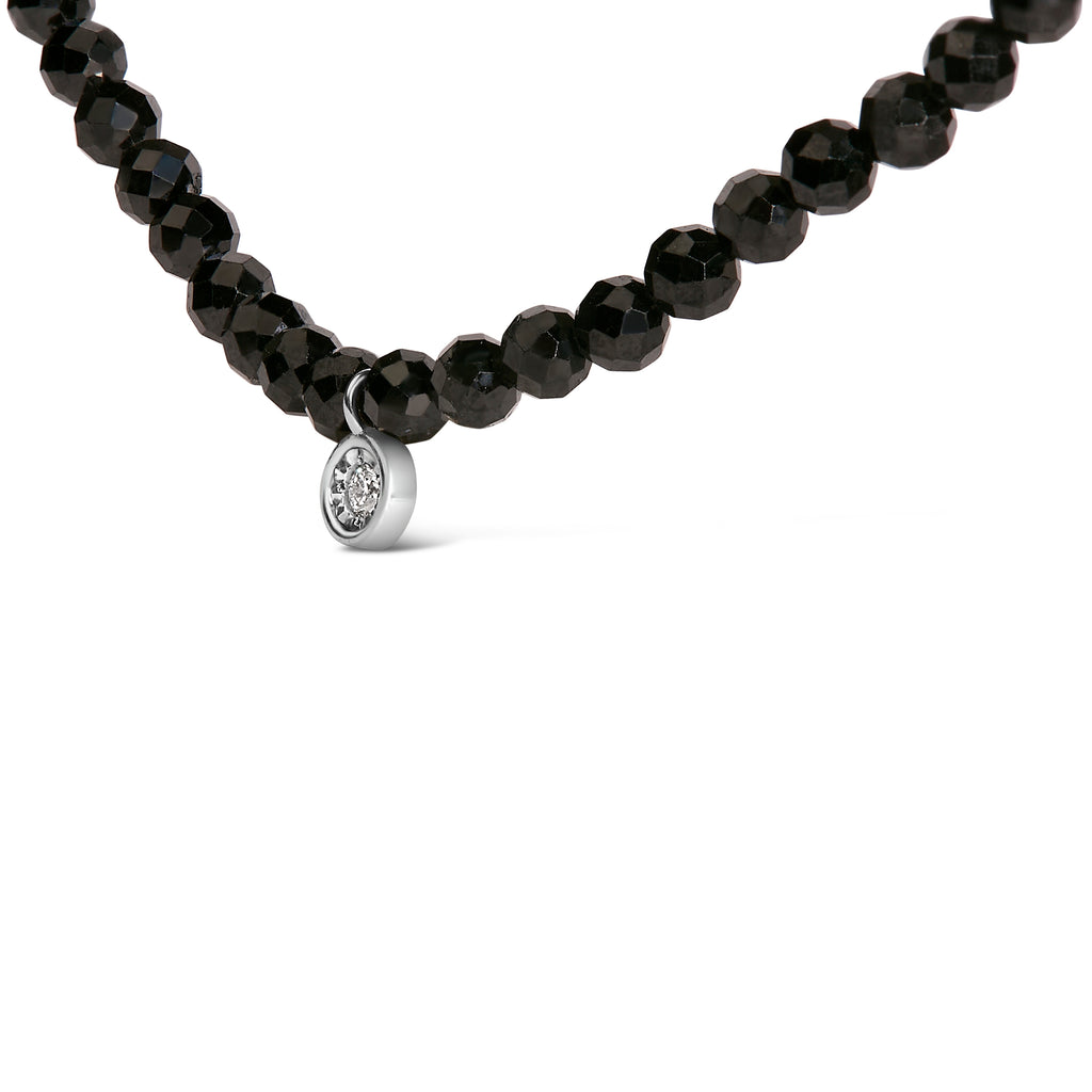 Black beaded necklace with a silver pendant on a white background