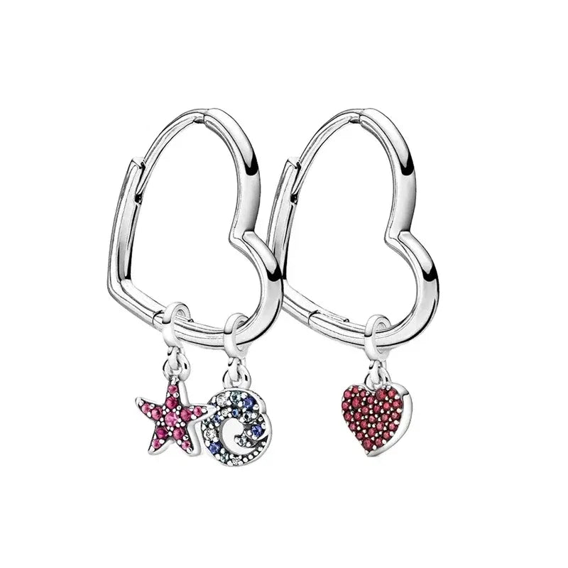 Heart-shaped hoop earrings with star, moon, and heart charms on a white background