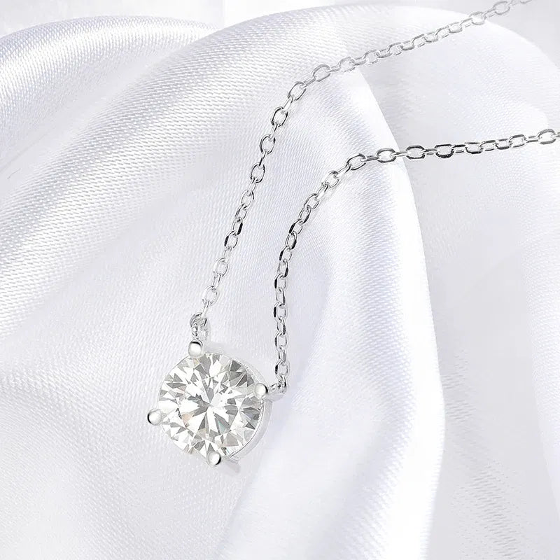 Silver necklace with a heart-shaped diamond pendant on a white satin background