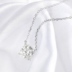 Silver necklace with a heart-shaped diamond pendant on a white satin background