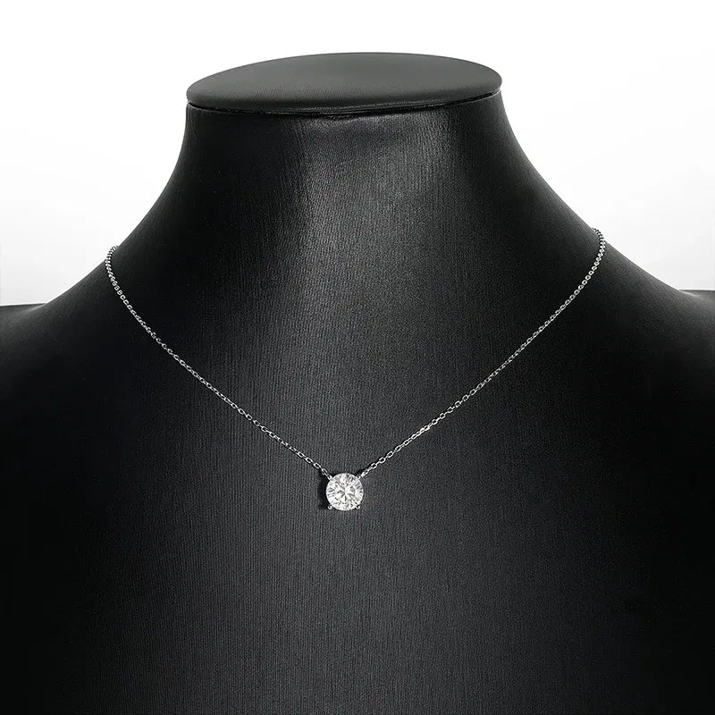 Silver necklace with a round pendant on a black mannequin bust.
