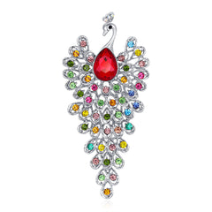 Jewelry pendant shaped like a peacock with multicolored gemstones on a white background